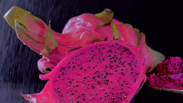 Wet Cutting Pitahaya Dragonfruit on a Black Background Closeup Rotation