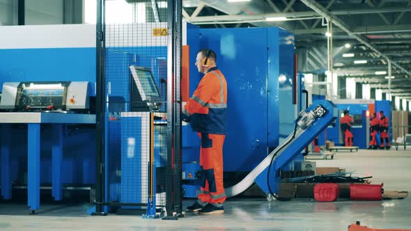 Engineer Working on an Assembly Line at a Modern Industrial Factory