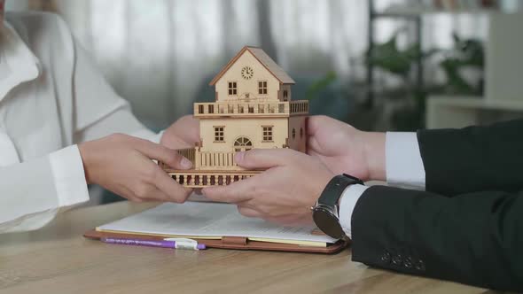 Close Up Of Real Estate Agent Giving The House Model To A Woman