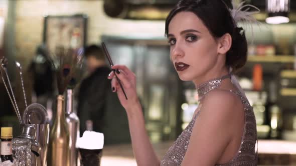 Closeup Portrait of a Young Attractive Woman in a 1920s Style at the Bar