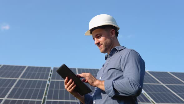 Engineer Solar Photovoltaic Panels Station Checks with Tablet Computer