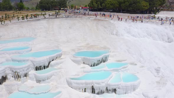 Fly Over Natural Travertines in Pamukkale with Lots of Tourists on the Background