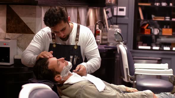 Man getting his beard shaved with razor