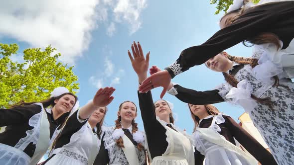 Happy Female Graduates Join Hands on Graduation Day