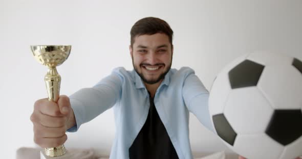 A Young Indian Football Fan is Watching TV at Home