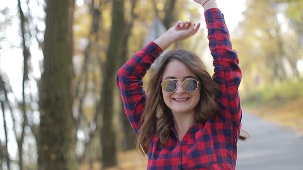 Beautiful brunette girl walks in the autumn park