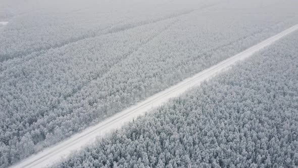 Aerial Top View From Drone Birds Eye View of Winter Landscape and Snowy Ice Road Car Moving on Area