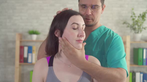 Male Chiropactic Massage Therapist Treats Young Patient From Neck Pain Close Up