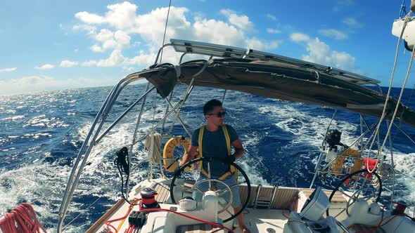 Blue Sea with a Man Navigating a Sailboat Through It. Ocean, Sea Sailing Boat Controlled By a Young