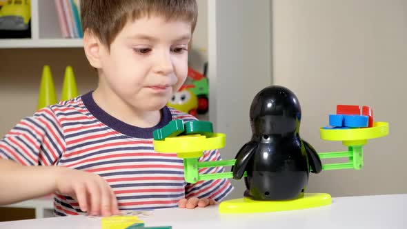 A Preschool Boy Learns Numbers Weighs Numbers on a Penguin Scale