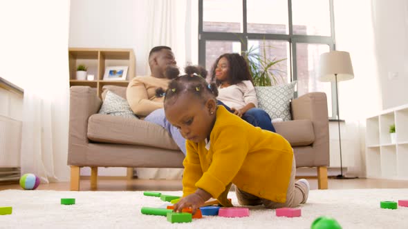 African Baby Girl Playing with Toy Blocks at Home