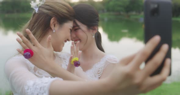Happy Asian Lesbian Married Couple Take A Photo Selfies Together By Smartphone.