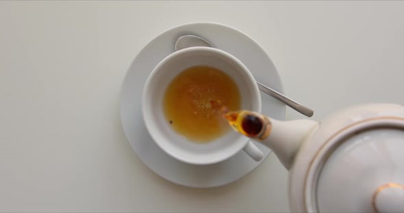 Tea From the Kettle Slowly Pour Into Porcelain Cup