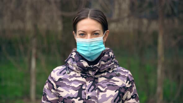Young Woman Takes Off Medical Mask and Looks at Camera. Healthcare and Medical Concept. Pandemic