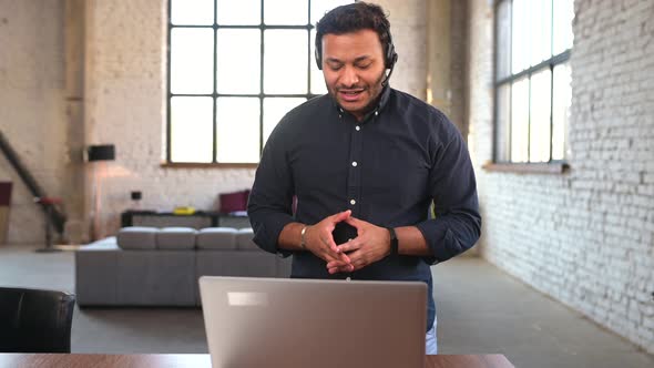 Serious Indian Man with Headset Talking with a Client