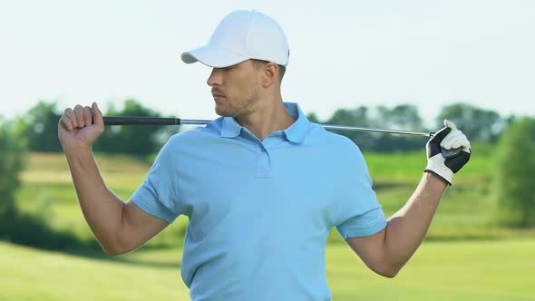 Confident Golf Player Warming-Up Back and Shoulders Muscles Before Hitting Ball