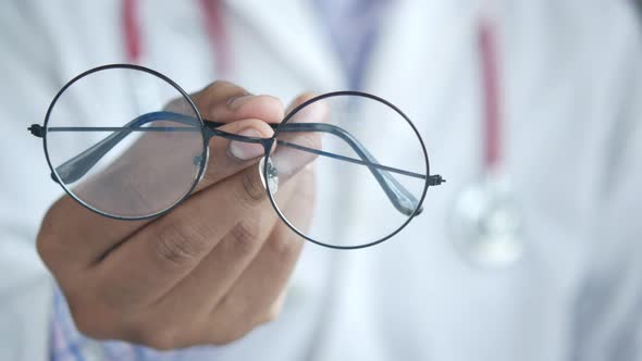 Doctor Hands Giving Pair of Black Glasses to Patient