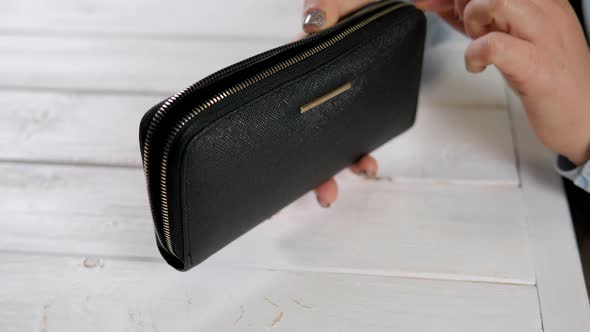 Hand of a Woman with an Empty Wallet and Two American Dollars Closeup