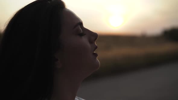 Confused Woman Sighs Heavily and Throws Her Hair on Face at Roadway in Evening