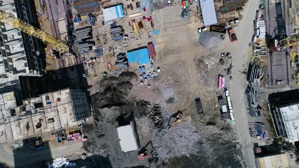 Flying over construction site. Excavators remove rubble, stones. Drone footage