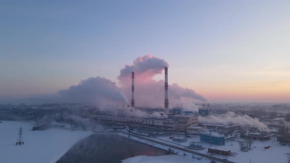Industrial zone with pipe thick white smoke from the factory chimney at winter