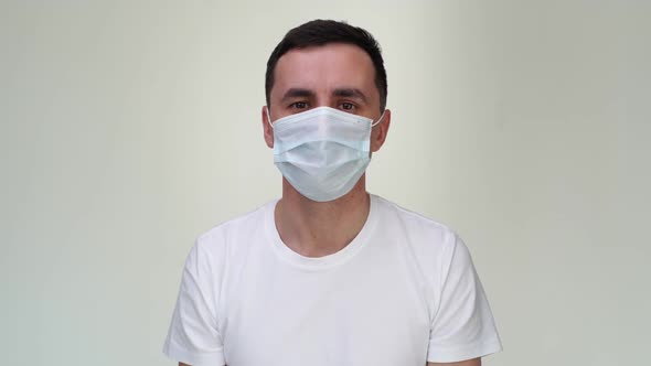 Scared Young Man in Medical Mask Suffocates in Front of the Camera.