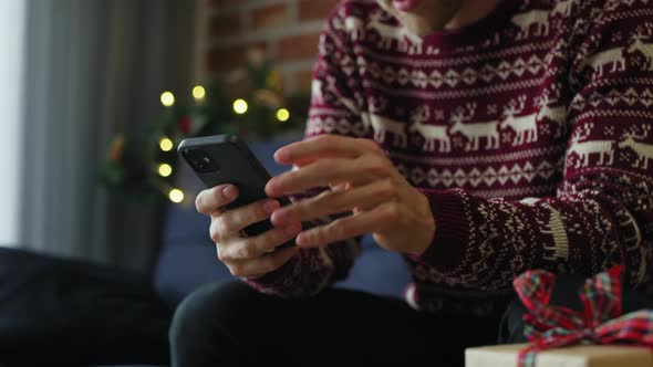 Man using mobile phone at home at Christmas time. Shot with RED helium camera in 8K