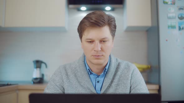 Young Attractive Man Working at Home at the Computer