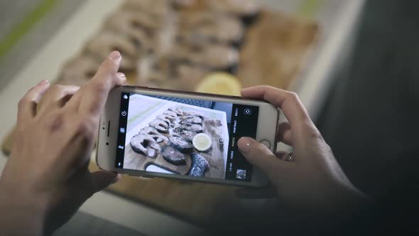 Female Hands Takes Photos with Fish Set on Phone Camera