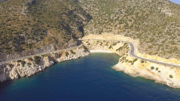 Cars Drives Down the Asphalt Road Running Along Mediterranean Shoreline with Azure Sea and Beach in