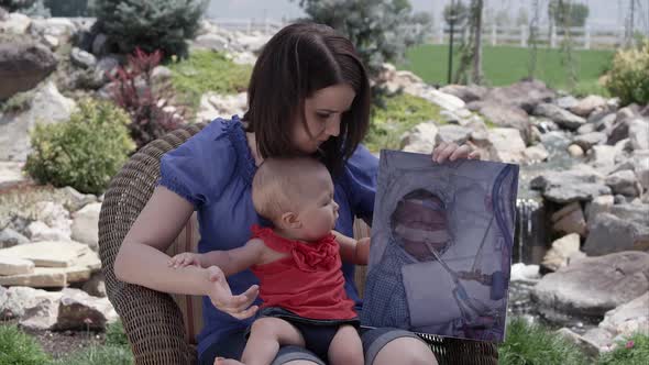 Slow motion of woman holding baby girl and picture of her in the hospital.