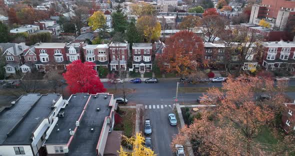 Brownstone homes in USA. Aerial reveal with colorful autumn fall foliage. Suburban scene from drone