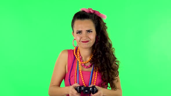Girl Playing a Video Game Using a Wireless Controller and Loses. Green Screen