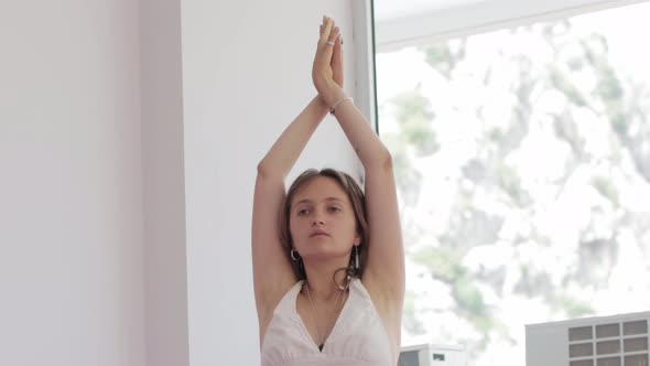 Young Woman with Tattoos Doing Yoga in the Studio
