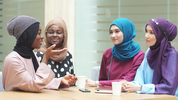 Young Muslim Female Tourists Sitting in Cafe at the Airport