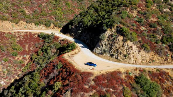 Panning left shot of a blue Tesla Model S on Mt. Baldy in Southern California.