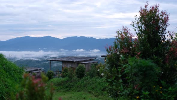 A wooden cottage with mountain views on foggy day