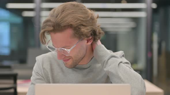 Portrait of Businessman with Laptop Having Neck Pain