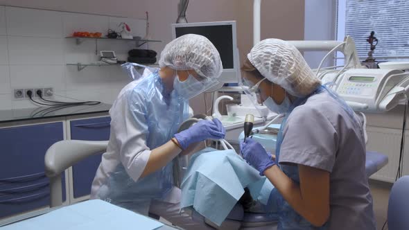 Close-Up Of Two Female Dentists Performing Surgery On A Patient's Teeth, Modern Dentistry