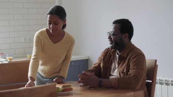 Positive father and daughter getting ready to have breakfast