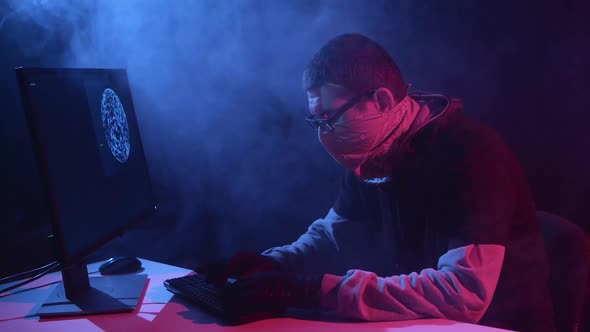 Spy Enters Virus Data Into the Computer. Black Smoke Background