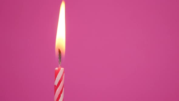 Candle Fire on a Birthday Cake Celebration on a Pink Background