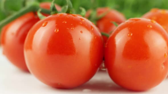 Ripe natural tomatoes close-up. Organic tomato rotating on a green background Macro shot.