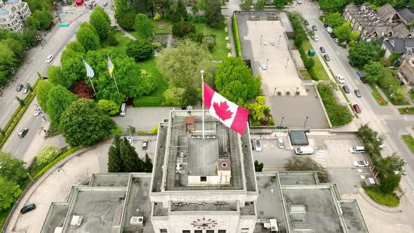 Vancouver Town Hall With Canadian Flag On Its Rooftop At Daytime In Vancouver, BC, Canada. - aerial