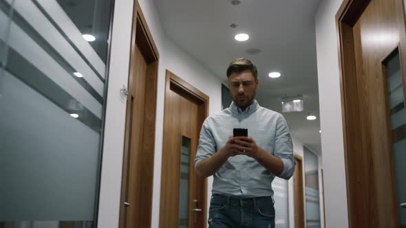 Successful Businessman Calling Phone Walking in Office Hallway