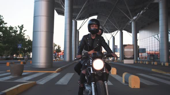 Young Couple in Helmets Riding on Motorcycle in City During Sunset Slow Motion