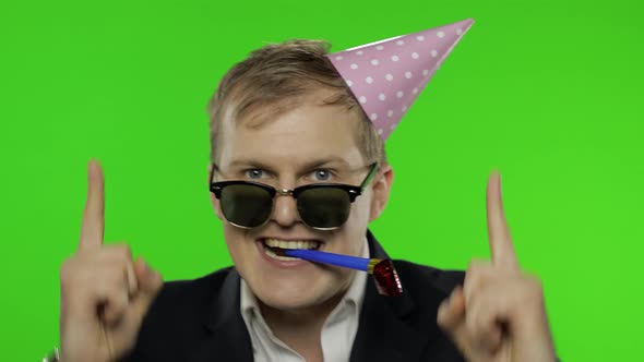 Drunk Disheveled Young Businessman in Festive Cap Celebrates and Dances