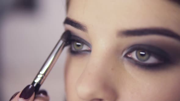 Makeup Artist Applying Eye Shadow Makeup to Model's Eye