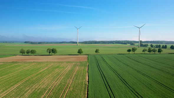 Beautiful farmland, windmills, lush green crops. Aerial drone.