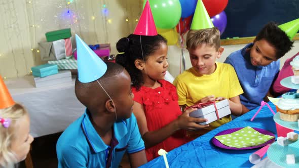 Friends giving gift box to girl during birthday party 4k